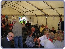 Audience gather for slide show in tent.